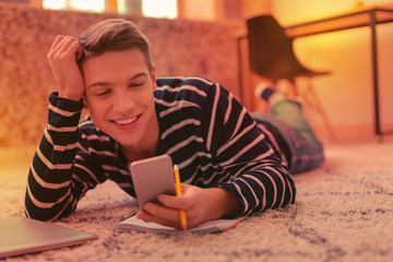 Dreamful positive guy distracting from home assignment