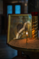 Candles in Russian orthodox cathedral with icons on background
