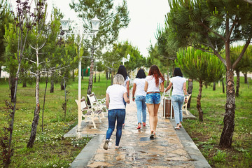Fototapeta na wymiar Group of friends women walking in park