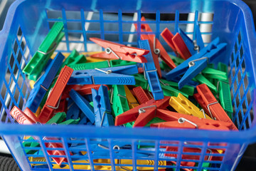 Colorful clothespins in a blue basket