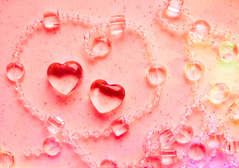 Transparent hearts and beads on marble in pink tone. Perfect Valentine's Day greeting card background.