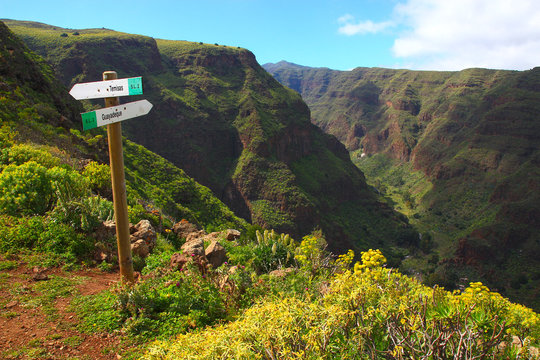 March in Gran Canaria (Canary Islands &ndash; Spain). Overview of the Guayadeque barranco, a lush and humid land. 2 hiking signs point to Temisas and Guayadeque.