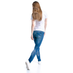 Woman in jeans and white t-shirt walking goes on white background isolation, back view