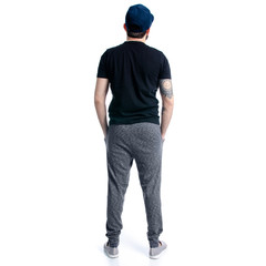 Fototapeta premium Man in black t-shirt with cap looks on white background isolation, back view
