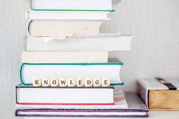 Books on desk with word knowledge as text motivation on dice