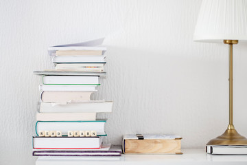 Books on desk with words read and learn as text motivation on dice