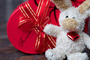 Chocolate box for Valentines Day on wooden background. Gift boxes and soft toy for a Valentines Day