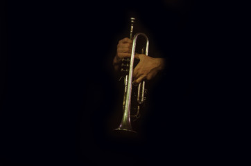 Trumpeter's hands with trumpet, jazzman in the dark, trumpet, music concert concept