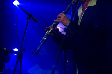 Artist, musician performing jazz with clarinet in the blue light, scene, performance concept