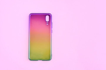 Gadget silicone colorful case with selective focus for mobile phone on neutral pink background. Cellphone protection casing accessories. Rainbow design fashion cases for smartphone. Plastic gadget cov