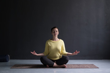 Casual pretty woman meditating on the floor