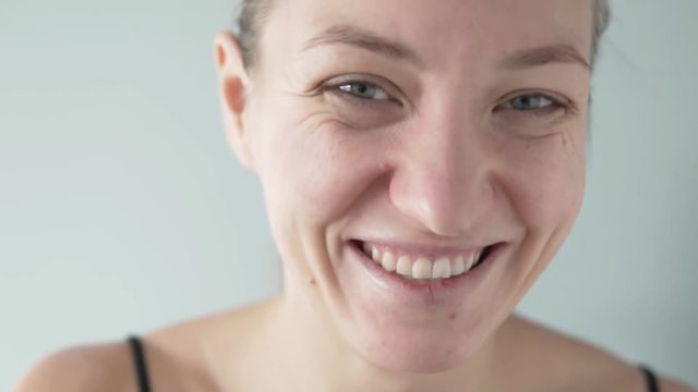 A young woman applies moisturizing gel patches under her eyes. She cares for her skin and applies a mask. Close-up girl cute smiling