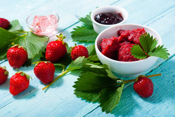 strawberry fruits with jelly, jam, marmalade on old blue table