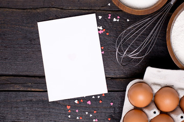 Present card , kitchen tools and hearts on a wooden background