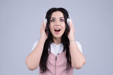 Naklejka premium Wonderful cheerful beautiful young caucasian brunette woman found her favourite track in playlist. Internet radio or broadcast podcast listener.