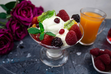 juice in a glass, ice cream with berries. and mint background. roses