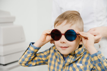 Ophthalmologist tests child kid boy color blindness, eye vision test