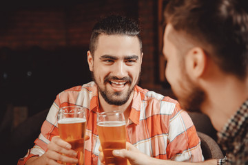 Happy friends met bar with glass of beer, joking, having fun. Concept sports pub