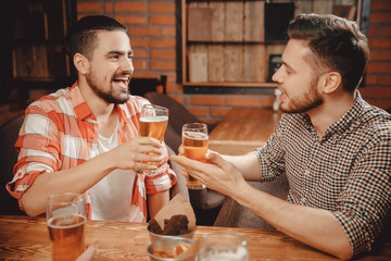 Friends tell jokes to each other in bar over glass of beer. concept spending time