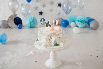 Smashed first birthday cake. Smash cake. One year. Blue colour. Messy pieces. Birthday cake with candle.