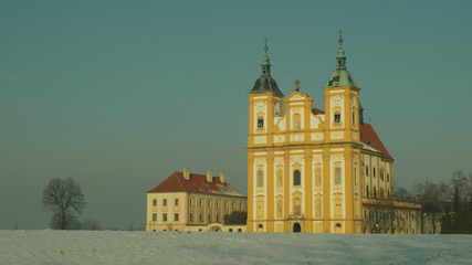 Pilgrimage church Ocistovani Panny Marie in winter snow, in the Dub nad Moravou, a solitary tree in field magic beautiful and nice landscape, historical Baroque architecture landmark Czech