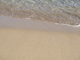 Soft wave of blue ocean on sandy beach. Background.