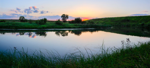 Beautiful summer landscape with river and trees at sunset