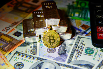 golden bitcoin cryptocurrency against the background of fiat money and precious metals silver