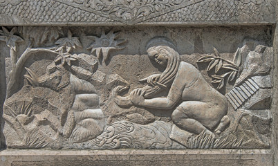 Stone relief panel showing tradional Chinese scene. Woman washing her hair in a stream.