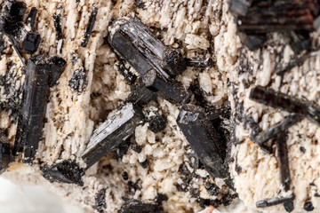 Macro mineral stone Schorl, Black Tourmaline on the feldspar on a white background