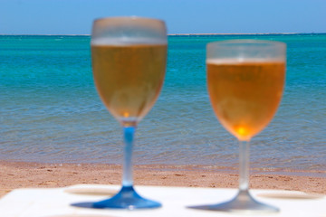 Two glasses of cold beer by sea. Chilled beer in glasses on table on seacoast