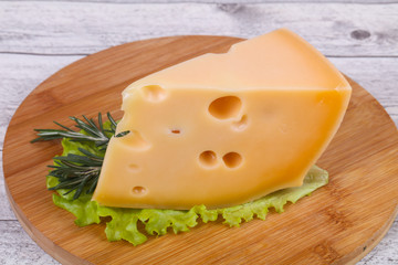 Maasdam cheese  in the board served salad leaves