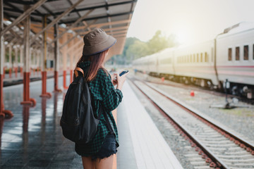 Young woman asian with backpack at the train station. Travel concept.