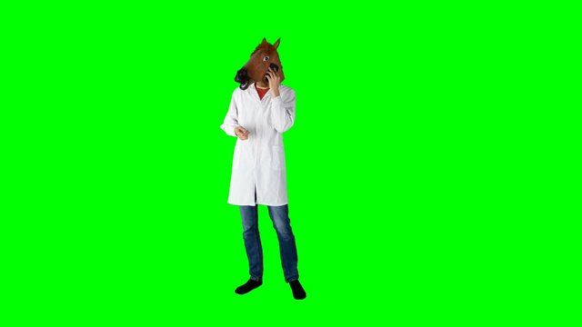 Hilarious Doctor in Lab Coat and Horse Head Mask Taking a Call on Green Screen