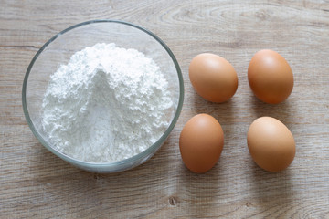 eggs and flour on wooden table