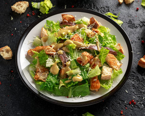 Caesar salad with chicken, anchous fish, croutons, parmesan cheese and greens. healthy food