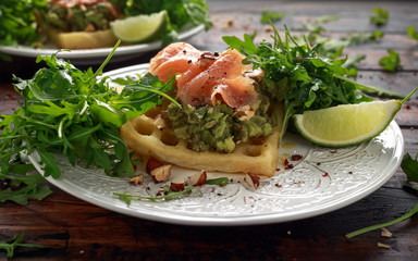 Potato waffles with avocado guacamole and smoked salmon for breakfast