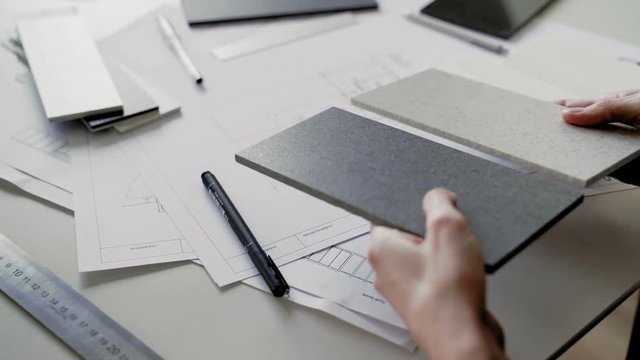 Woman fills data in graphs on paper. Records information. Woman is engaged in office work. Graphic charts,indicators. Woman works at the offside table. Woman draws symbols on the paper