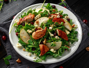 Pear, chicken salad with blue cheese, cranberry and walnuts. concept healthy food. black background