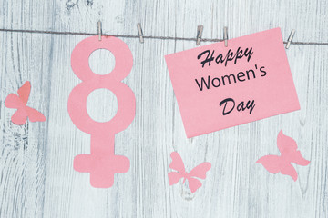 Women's Day Concept. The symbol of Venus. Pined on the clothespins paper figure eight and inscription Happy Women's Day