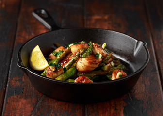 Scallops seared in garlic and parsley butter served in cast iron skillet