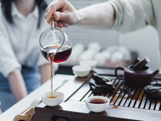 Obraz na płótnie Canvas Chinese tea ceremony. Master pouring puer tea in cups. Pu erh tea ceremony.