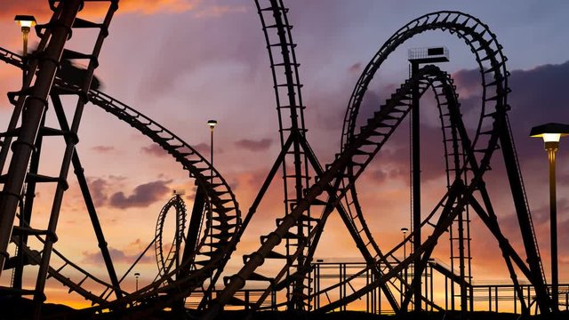 roller coaster thrill ride at amusement park at sunset with car - 3d animation.