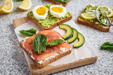 Healthy avocado and egg toasts. Toast, avocado, egg, tomatoes, spinach, cheese Feta, lemon. Organic healthy food. Clean healthy eating