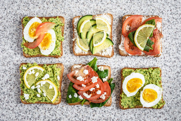 Healthy avocado and egg toasts. Toast, avocado, egg, tomatoes, spinach, cheese Feta, lemon. Organic healthy food. Clean healthy eating