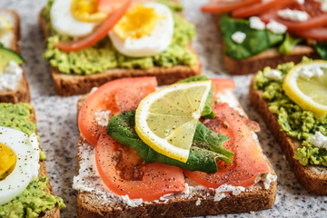 Healthy avocado and egg toasts. Toast, avocado, egg, tomatoes, spinach, cheese Feta, lemon. Organic healthy food. Clean healthy eating