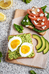 Healthy avocado and egg toasts. Toast, avocado, egg, tomatoes, spinach, cheese Feta, lemon. Organic healthy food. Clean healthy eating