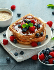 French cinnamon toast with blueberries, raspberries, maple syrup and coffee. morning breakfast