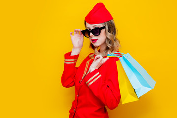 stewardess wearing in red uniform with shopping bags.