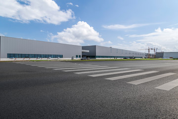 Road asphalt pavement and modern factory warehouse..